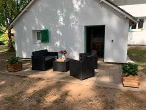 a white house with two couches and a table at Charmante annexe au cœur d'un joli parc arboré in Moncé-en-Belin