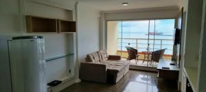 a living room with a couch and a balcony at Yacht Coast in Fortaleza