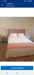 a picture of a bedroom with a bed with avertisement at La Rua 25 in Castro-Urdiales
