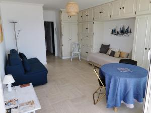 sala de estar con mesa azul y sofá en La Calypsette - Face Grande Plage des Sables d'Olonne, en Les Sables-dʼOlonne
