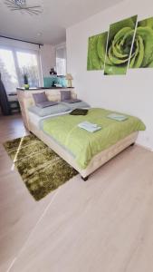 布拉格的住宿－機場附近巴斯蒂安公寓，一间卧室配有一张带绿色棉被的床
