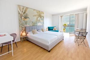 une chambre avec un lit, un canapé et une table dans l'établissement Garden Hotel Primavera, à Brissago