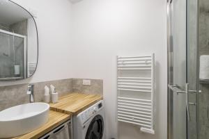y baño con lavabo y lavadora. en L'EUCALYPTUS - Charmant appartement de 52m2 en Dinard