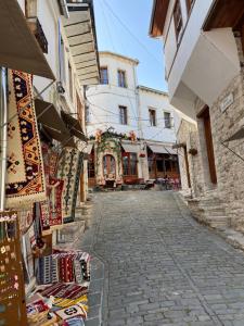 una calle con un grupo de tiendas y edificios en Ballo Apartments en Gjirokastër