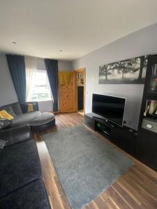 a living room with a couch and a flat screen tv at Town villa with charming garden, bbq area & Sleeps 6 in Cashel