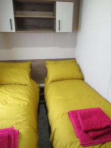two beds sitting next to each other in a room at Chichester Lakeside Self-Catering Holiday Home in Chichester