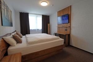 sypialnia z dużym łóżkiem i telewizorem w obiekcie Hotel Kreuz Höhengasthof w mieście Breitnau