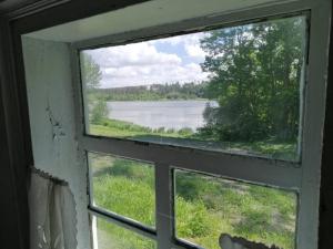 an open window with a view of a lake at У Катерини in Dvozhets