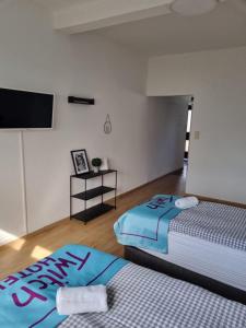 a bedroom with two beds and a flat screen tv at Twitch Appartments in Achim