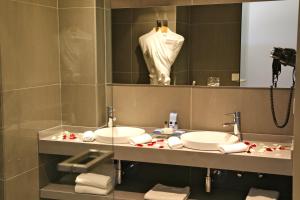 a bathroom with two sinks in front of a mirror at Pangea Beach Resort in Jiyeh +24 photos