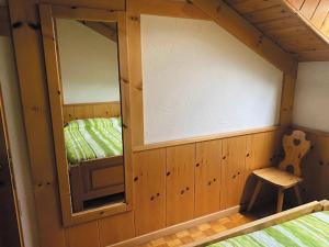 Habitación con espejo y silla en una cabaña en Minghetti en Predazzo
