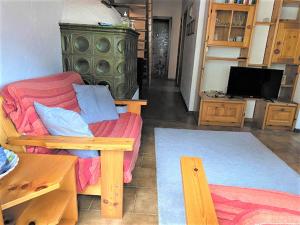 - un salon avec un canapé et une télévision dans l'établissement Minghetti, à Predazzo
