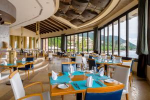 a restaurant with tables and chairs and large windows at Garza Blanca Preserve Resort & Spa in Puerto Vallarta