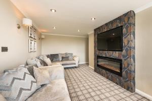 a living room with a fireplace and a tv at Blanerne House in Duns