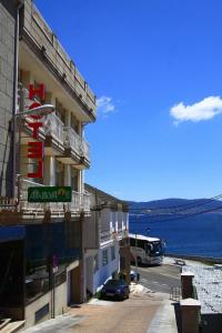 un hotel con un autobús estacionado junto al océano en Hotel Atalaya II, en Portonovo