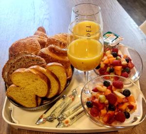 - un plateau avec du pain grillé et un verre de jus d'orange dans l'établissement Les Rêves by Isa, à Arras