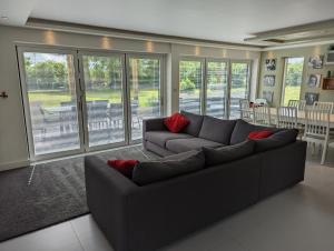 a living room with a gray couch and red pillows at Unique, Spacious, Self-Built Eco Home with huge garden and movie room in Andover