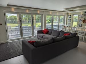 アンドーバーにあるUnique, Spacious, Self-Built Eco Home with huge garden and movie roomのリビングルーム(グレーのソファ、赤い枕付)
