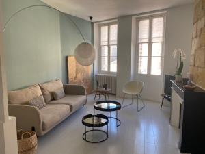 salon z kanapą i dwoma stołami w obiekcie Bô, Peace & Bordeaux w mieście Bordeaux