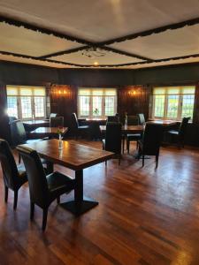 a dining room with tables and chairs and windows at Jersey Arms Hotel Bicester in Bicester