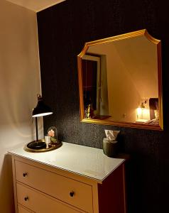 a dresser with a mirror and a lamp on it at Luxus Ferienhaus Erzgebirge in Alleinlage in Kurort Altenberg