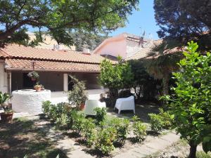 a garden with two chairs and a house at LA CASA DI MARTA in Milazzo