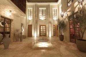 a large room with a fountain in the middle of a building at Riad Joya in Marrakesh