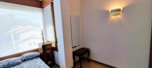 1 dormitorio con 1 cama y una luz en la pared en Apartamento Vacacional Roma en Barro de Llanes
