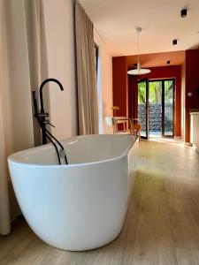 a white bath tub in a room with a table at Domki MODERN Jezioro Nyskie in Nysa