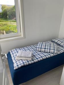 a bed with two pillows on it next to a window at Feriehus med Sjøutsikt in Sætra