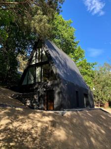 a black house with a roof with windows at Domki MODERN Jezioro Nyskie in Nysa