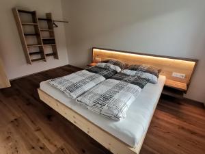 una cama con sábanas y almohadas en una habitación en Ferienwohnung Lotterhof, en Heinfels
