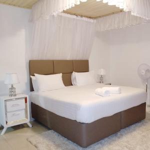 a bedroom with a large bed with white sheets at Sofitel 3 bedrooms own compound milimani in Kisumu +18 photos