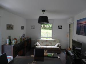 een woonkamer met een bank en een televisie bij Séjour inoubliable en baie de SOMME, logement neuf in Saint-Valery-sur-Somme