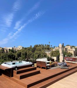 una terraza con bañera de hidromasaje, mesa y sillas en TEL AVIV - Sea front Penthouse - 1604, en Tel Aviv