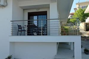 a balcony of a house with a table and chairs at Melograno Apartment in Ammouliani