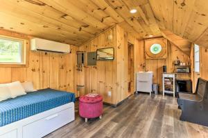 a bedroom with a bed in a room with wooden walls at Cozy Upstate Studio with Walkill River Views! in New Paltz