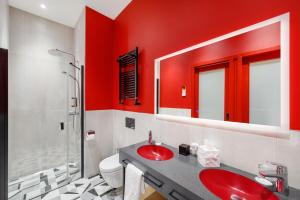 a red bathroom with a sink and a shower at Hotel Oktogon Haggenmacher in Budapest