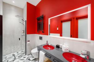 La salle de bains rouge est pourvue d'un lavabo et d'une douche. dans l'établissement Hotel Oktogon Haggenmacher, à Budapest