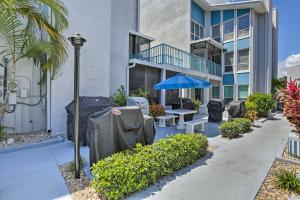 a building with a patio with a table and an umbrella at Poolside Madeira Beach Abode with Balcony! in St. Pete Beach