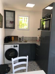 a kitchen with a washing machine and a sink at Nîmes calme in Nîmes