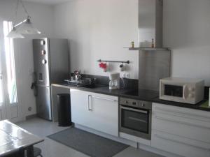 eine Küche mit einem Kühlschrank und einer Mikrowelle in der Unterkunft Appartement au village in Rutali