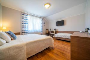 um quarto de hotel com duas camas e uma televisão em Pokoje gościnne Angela em Jastarnia