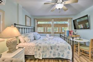 a bedroom with a bed and a ceiling fan at Dreamy, Coastal Studio Paradise with Hot Tub! in Nags Head