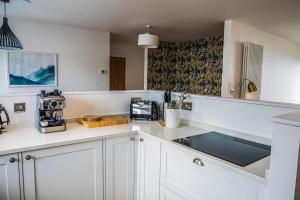 a kitchen with white cabinets and a counter top at 2 Bed Ground Floor Apartment - 7 Plas in Pistyll