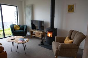 a living room with a fireplace and a tv at 2 Bed Ground Floor Apartment - 7 Plas in Pistyll