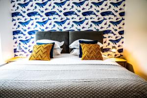 a bedroom with a bed with a blue dolphin wallpaper at 2 Bed Ground Floor Apartment - 7 Plas in Pistyll