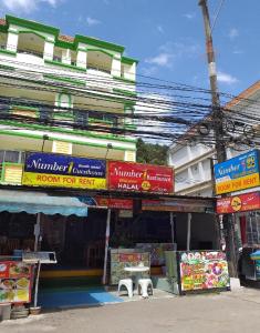 a building with colorful signs in front of it at Number 1 Guesthouse in Ao Nang Beach