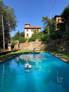una piscina de agua azul con un edificio al fondo en Apartamento tipo Loft, en Ribes de Freser