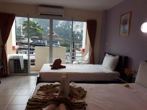 Dos camas en una habitación de hotel con dos niños. en Number 1 Guesthouse, en Ao Nang Beach
